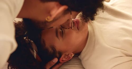 Young Adults Kissing in Bed, Loving Embrace