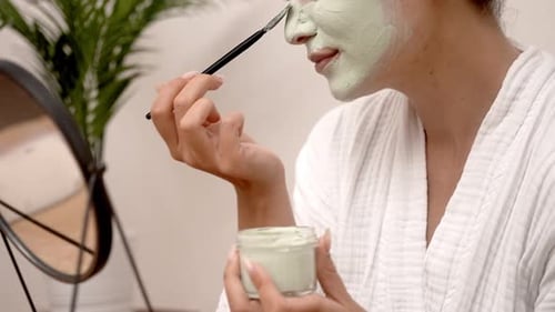 Woman Applies Cosmetic Face Mask At Home