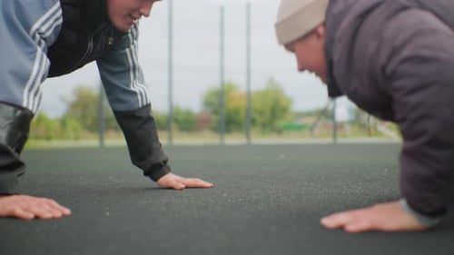 Young Men Do Push-Ups with Basketball Outside