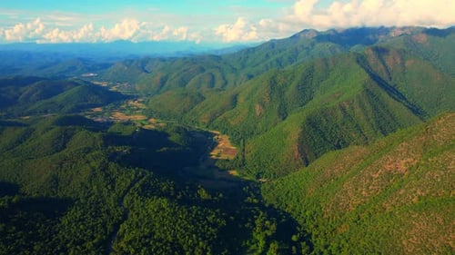 Aerial view over green valley in tropical forest during sunset