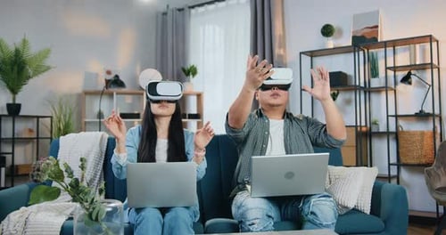 Young Adults Using VR Headsets With Laptops at Home