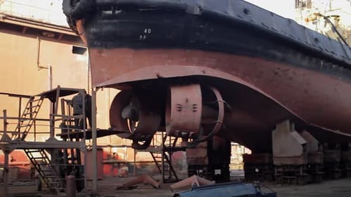 Trabalhadores reparam navio em doca seca com soldagem e manutenção de vasos de moagem em estaleiros industriais