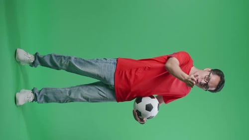 Asian Man With A Ball Blowing Kisses And Smiling To Camera While Cheering Soccer On Green Screen