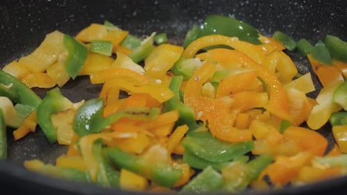Colorful Bell Peppers Cooking in a Dark Pan