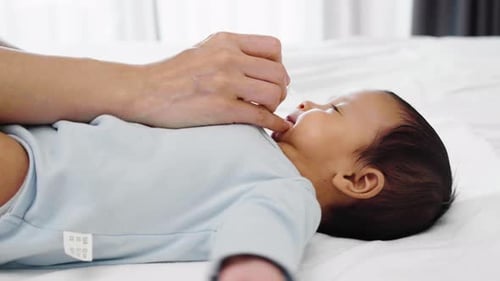 Infant Receives Medicine with Dropper Lying Down