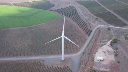 Luftaufnahmen von sich drehenden Windkraftanlagen in einer Umgebung eines Bergwaldes
