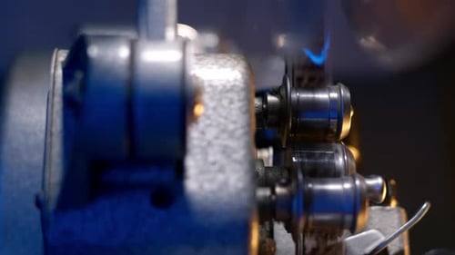 Extreme Close View of a Film Projector Reel Start to Spin and Play Film From Films in a Large Hall