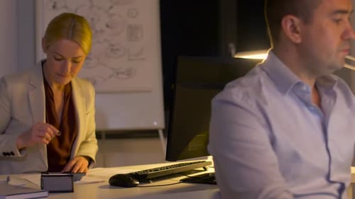 Office Workers Overtime at Desks with Computers