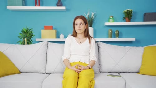 Thoughtful Woman Sitting on Sofa Thinking at Home
