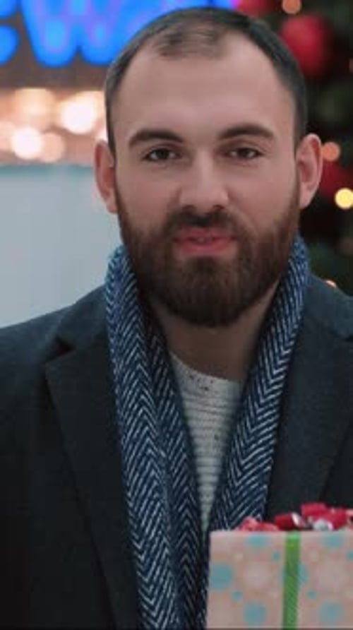 Bearded Man Holding Christmas Gifts and Smiling