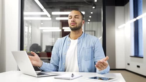 Man Meditating at Desk in Modern Office