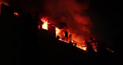 Huge Fire Blazing in Residential Building House is Engulfed in Flames at Night During the Disastrous