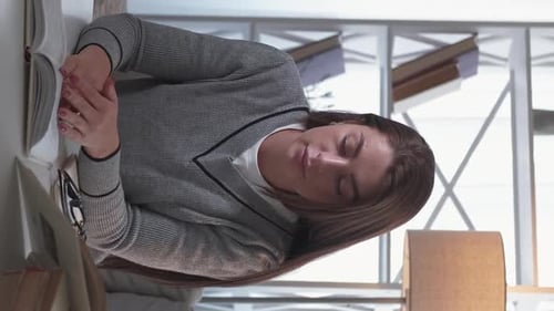 Woman Reading Book at Desk, Close Up