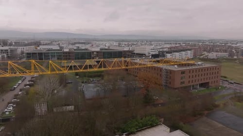 Tobogán aéreo y movimiento panorámico de una grúa torre en el sitio de construcción de un nuevo edificio, largo foque de celosía amarilla