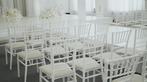 Closeup Wedding Hall Decoration in White Color Ready for Guests with White Color Chairs and White