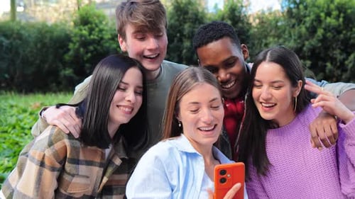Cheerful Friends Enjoying Phone in Urban Park