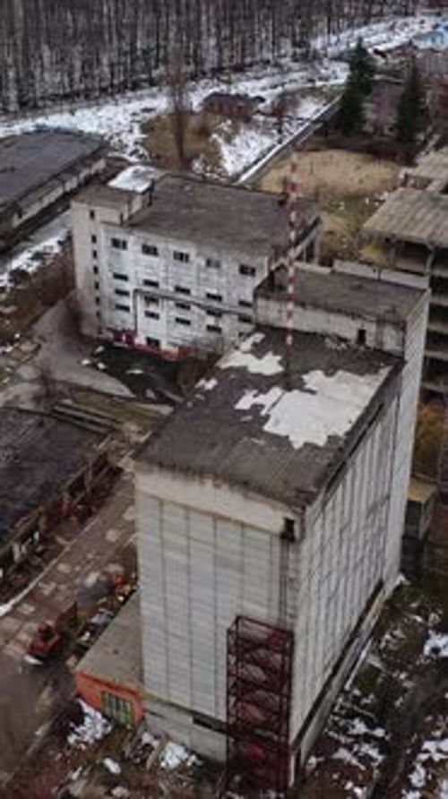 Aged factory with ruined buildings. Abandoned industry in dark background after the war.