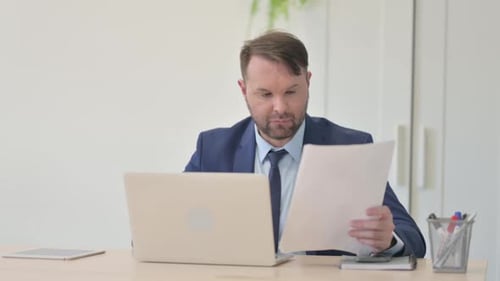 Excited Businessman Celebrating Achievement at Office Desk