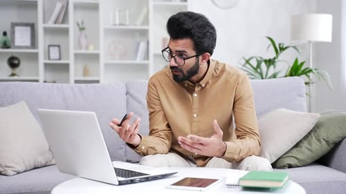 Young Adult Male Using Laptop For Video Conference
