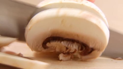 Slicing a Mushroom with Knife on Cutting Board