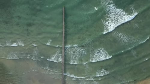 Luftaufnahme der schönen Wellen am tropischen Meer mit Holzsteg