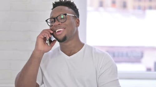 Man Talking on Smartphone Indoors Smiling