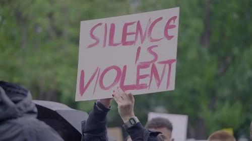 Crowd Holds Signs During a Protest Rally