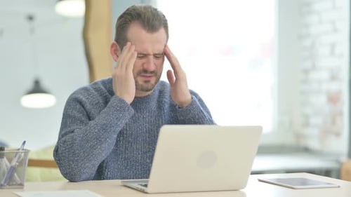 Man Experiencing Headache While Working at Computer
