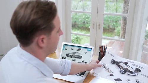 Un
designer automobile analyse soigneusement un prototype de voiture. Fastidieux