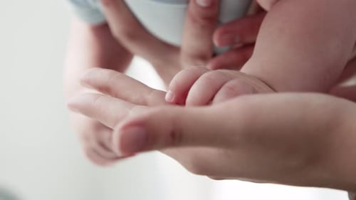 Infant Hand Held Tenderly in Parent's Palm
