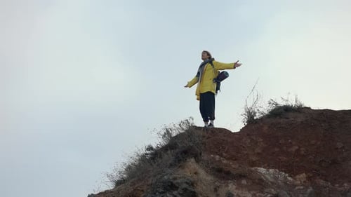 A Man Standing on Top of a Mountain with Outstretched Hands and Enjoying the View Low Angle View