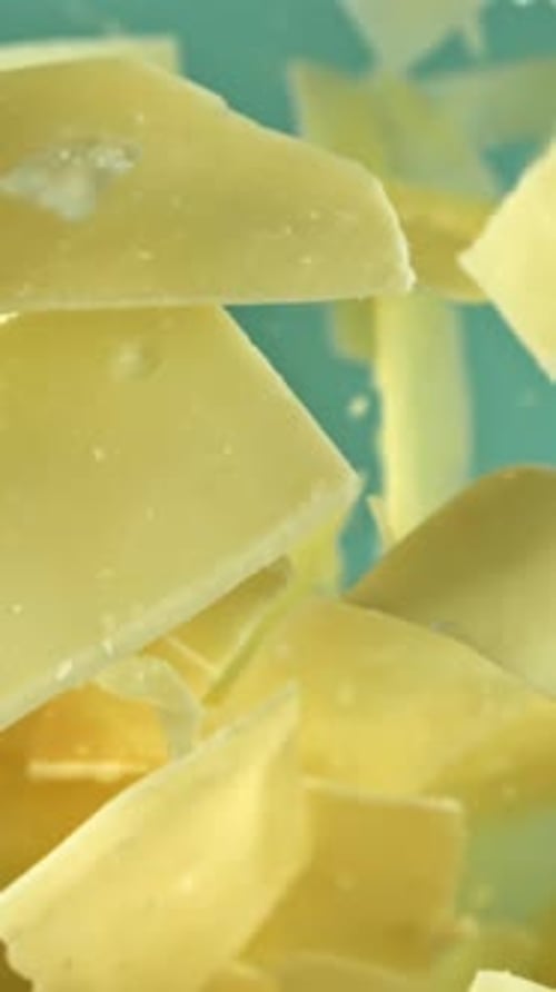 Parmesan Cheese Flies Up and Falls Down on a Blue Background Filmed on a Highspeed Camera at 1000