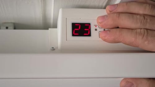 Man Lowering the Temperature on Electric Heater Close Up Person Adjusting Thermostat on Radiator to