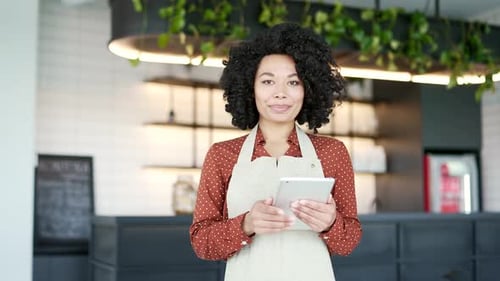 Smiling Woman with Tablet in Modern Cafe