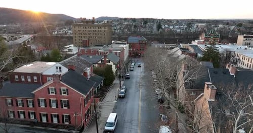 Puesta de sol dorada sobre la arquitectura histórica de ladrillo en una ciudad tranquila