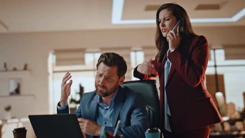 Worried Woman Talking to Man Working on Laptop
