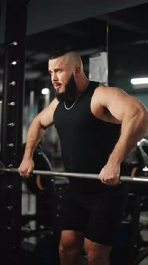 Muscular Athlete Performing Barbell Shrugs Displaying Raw Strength During Weightlifting Workout