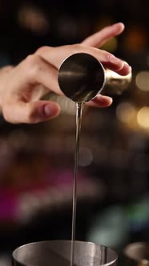Ein erfahrener Barkeeper kreiert fachmännisch einen frischen Cocktail hinter einer stilvollen Bartheke