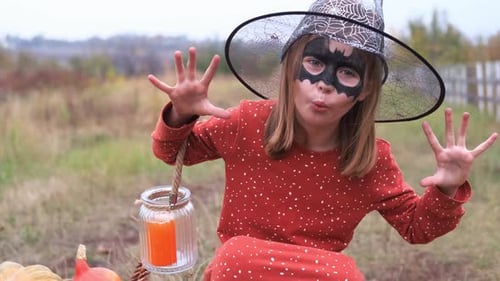 Girl in Witch Costume Poses Outdoors for Halloween