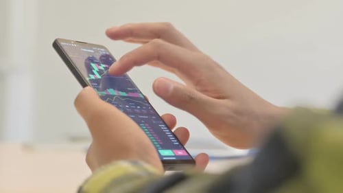 Close up of African Man Doing Trading on Smartphone