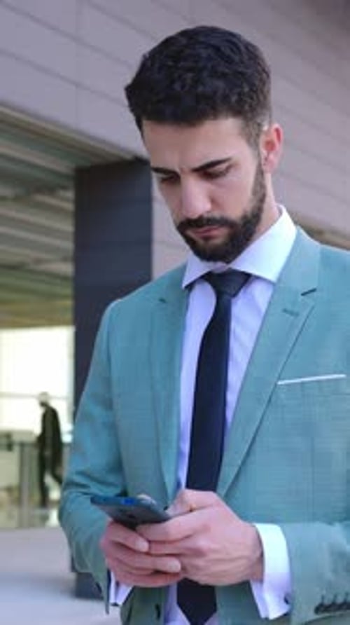 Businessman in Formal Suit Using Cellphone Standing Outside Building Office