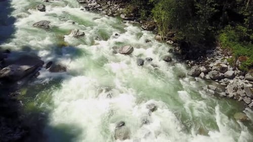 River Current Flowing in the Valley Around the Smooth Rocks During a Bright Sunny Spring Day