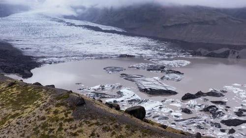 KvĂarjökull glacier with glacial lagoon on cloudy day, impressive Iceland landscape