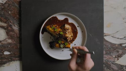Overhead shot of a chef plating a gourmet sweet potato dish in a restaurant