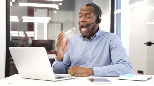 Professional Man Talking On Laptop Using Headset