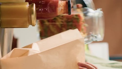 Vídeo vertical: cliente añadiendo pasta en una bolsa de papel