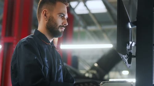 Auto mechanic diagnosing car engine with a laptop with special program at the car repair service