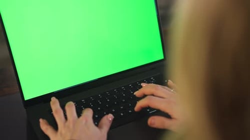 Woman's Hand Typing On a Laptop Keyboard With Green Screen. - closeup shot