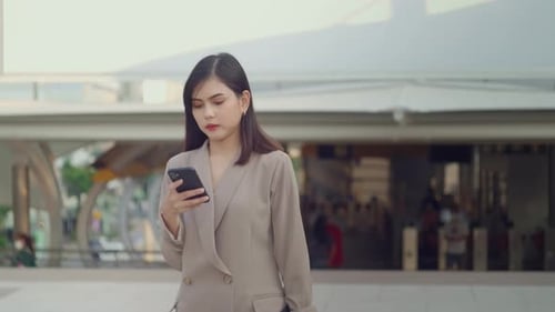 A young beautiful businesswoman is using Smart phone in Modern city