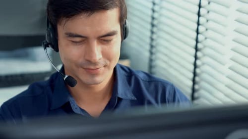 Young Competent Asian Male Call Center Agent Working in the Office